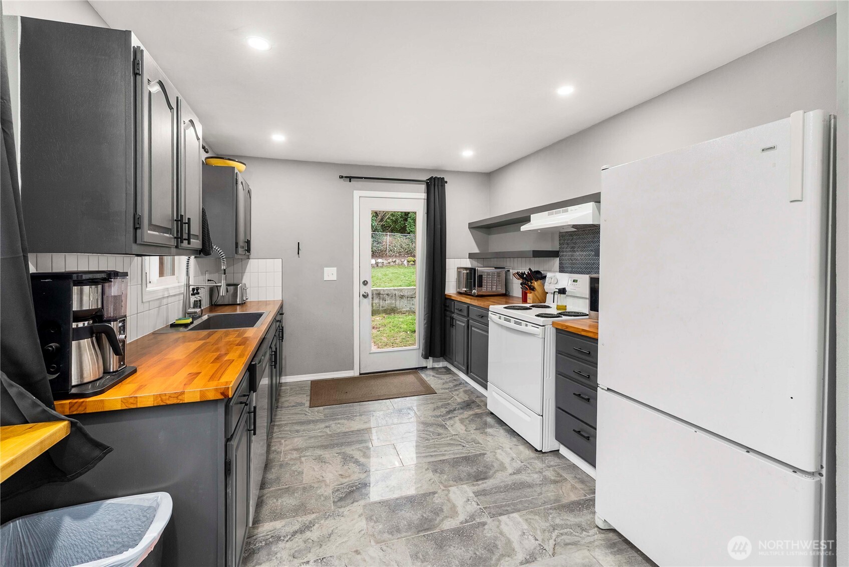 3608 South L Street Tacoma, WA 98418 - Photo 9 of 40 a kitchen with stainless steel appliances granite countertop refrigerator sink and cabinets