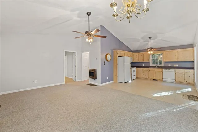 a kitchen with stainless steel appliances granite countertop a refrigerator a sink a stove a dining table and chairs