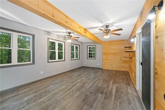 a kitchen with stainless steel appliances granite countertop a refrigerator a sink dishwasher a stove and white countertops with wooden floor