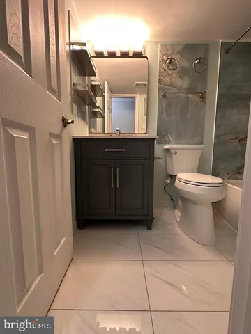 a bathroom with a toilet a sink and mirror