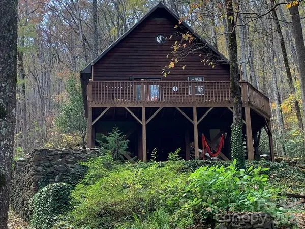 a view of house with balcony and trees
