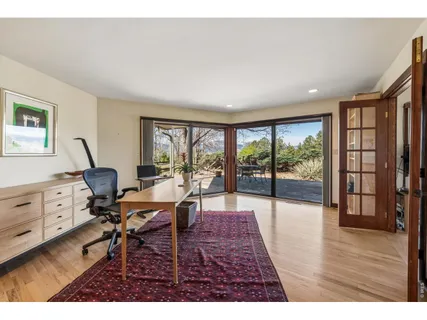 a living room with furniture large window and wooden floor