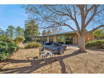 a view of a house with backyard and sitting area