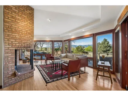a living room with furniture a rug potted plant and a large window
