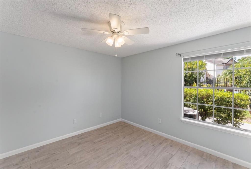 1908 Lake Atriums Circle, Unit 3 Orlando, FL 32839 - Photo 13 of 17 an empty room with wooden floor fan and windows