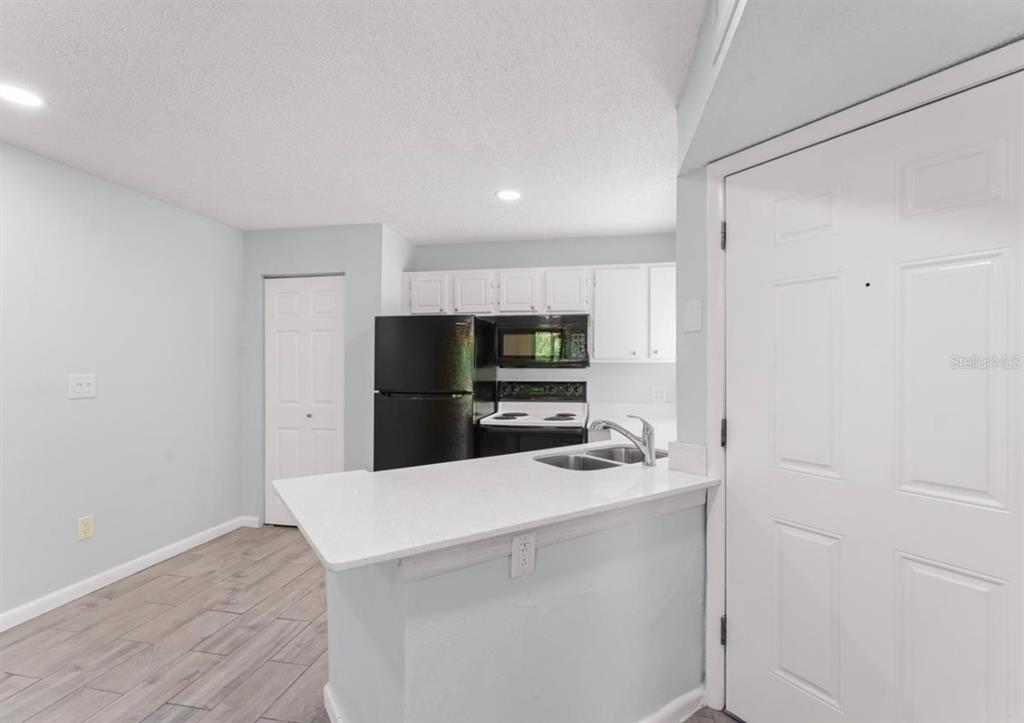 1908 Lake Atriums Circle, Unit 3 Orlando, FL 32839 - Photo 7 of 17 a kitchen with stainless steel appliances a refrigerator sink and microwave