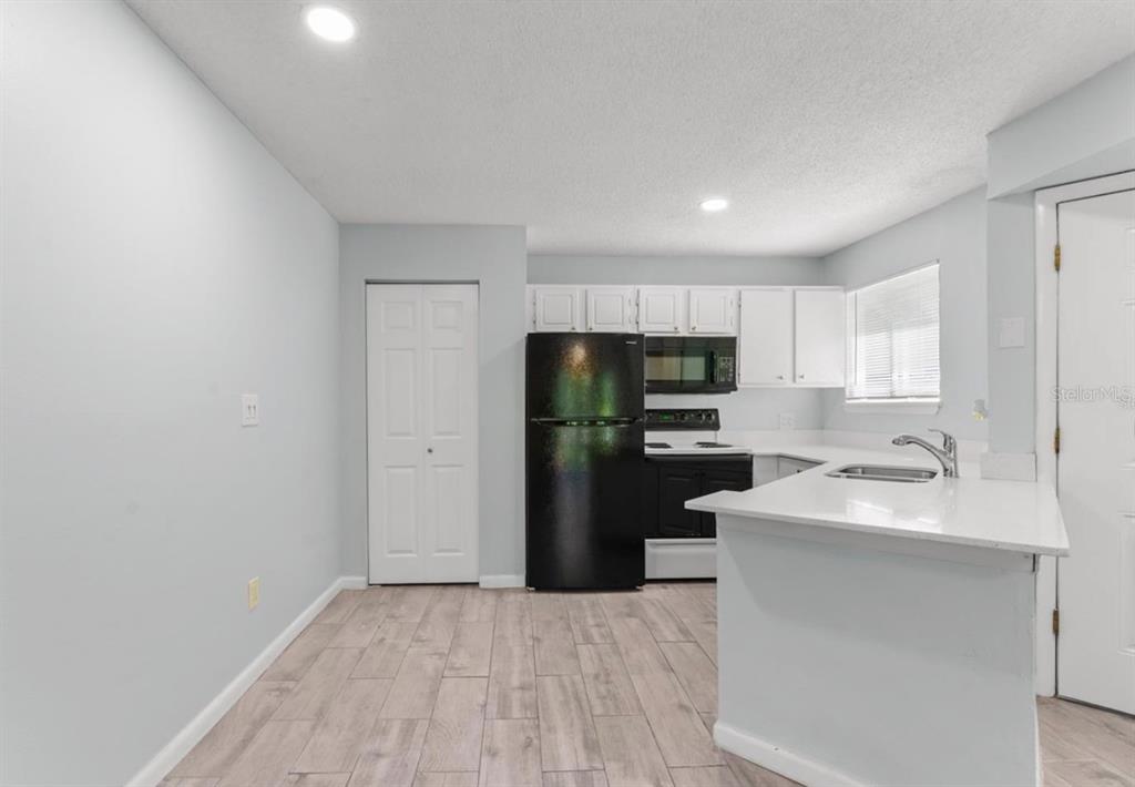1908 Lake Atriums Circle, Unit 3 Orlando, FL 32839 - Photo 8 of 17 a kitchen with a refrigerator sink and cabinets