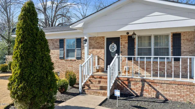 a view of a house with large windows and a tree