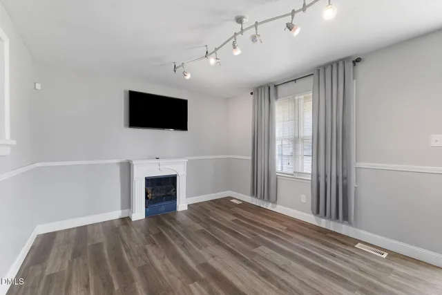 a view of a livingroom with a flat screen tv wooden floor and a fireplace