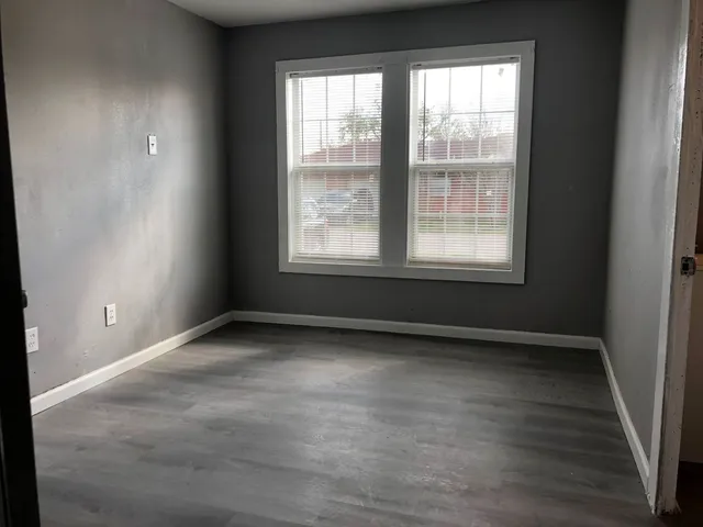 a brick house with a yard plants and large tree