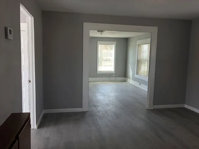 an empty room with wooden floor and a window
