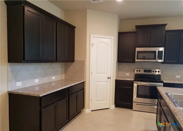 a kitchen with a sink stove and microwave