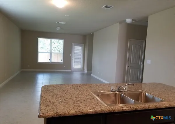 a bathroom with granite countertop a sink and a window