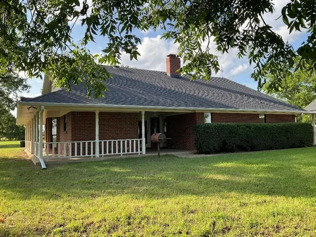 a view of a house with a yard and porch