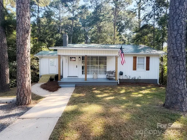 a view of a house with backyard and trees