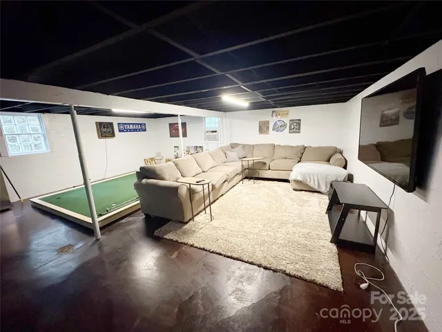 a living room with furniture gym equipment and a flat screen tv