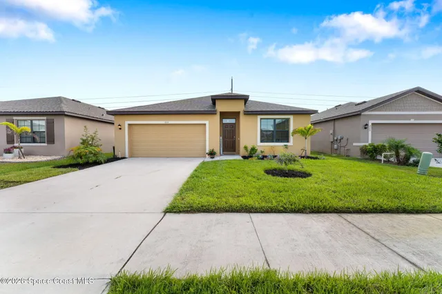 a front view of house with yard and green space