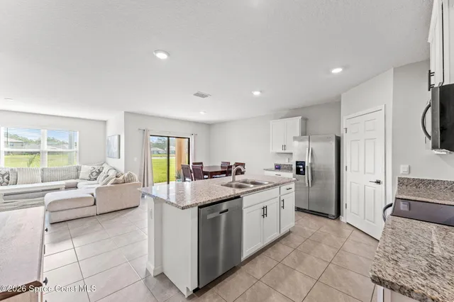 a large white kitchen with a stove a sink a washer and dryer