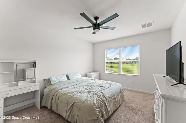 a bedroom with a large bed and a flat screen tv