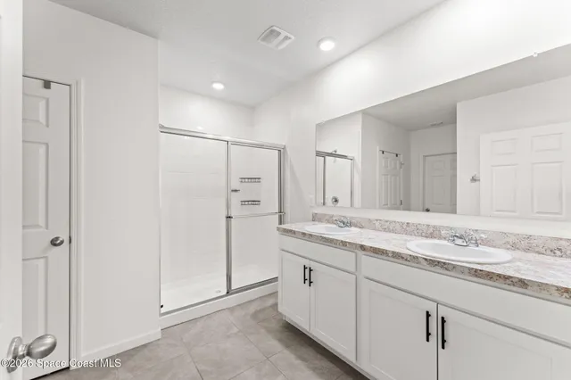 a bathroom with a granite countertop sink mirror and cabinets
