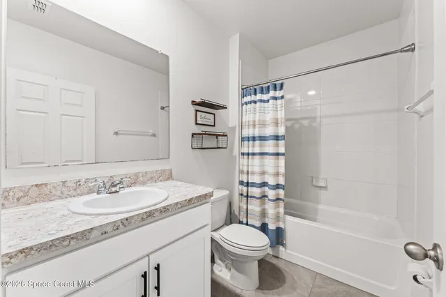 a bathroom with a granite countertop sink toilet mirror and shower