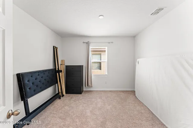 a view of hallway with furniture and a refrigerator