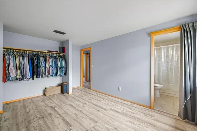 a view of hallway with wooden floor and livingroom