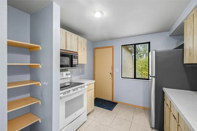 a kitchen with a stove cabinets and a refrigerator