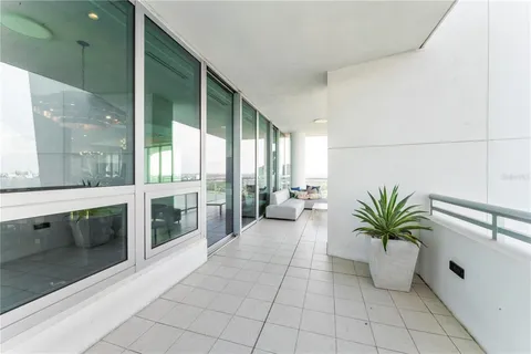 a living room with furniture a flat screen tv and a large window