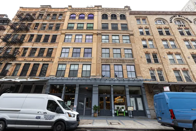 a front view of a building with car parked