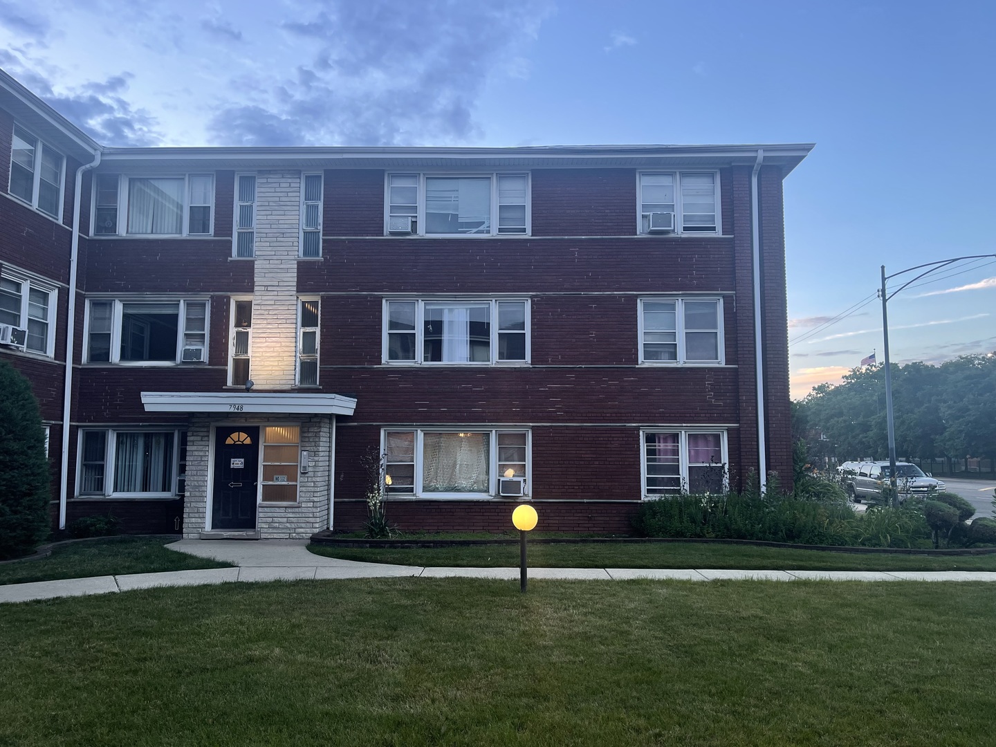 a front view of a building with a garden