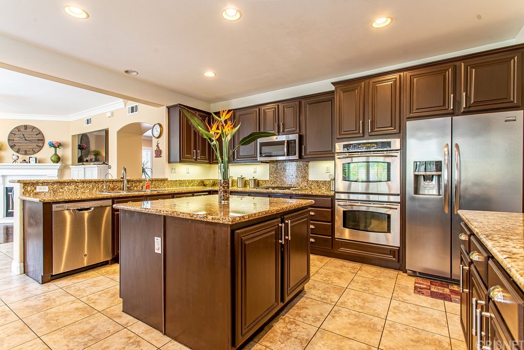 25054 Oliver Way Stevenson Ranch, CA 91381 - Photo 13 of 53 a kitchen with stainless steel appliances granite countertop a refrigerator and a sink