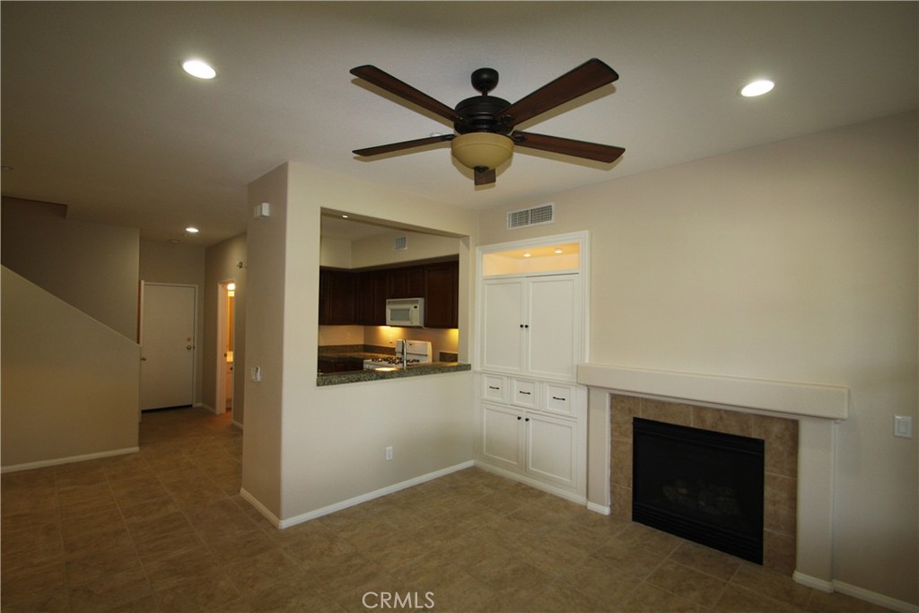 11 Rumford Street Ladera Ranch, CA 92694 - Photo 4 of 24 a view of living room with a fireplace and a ceiling fan