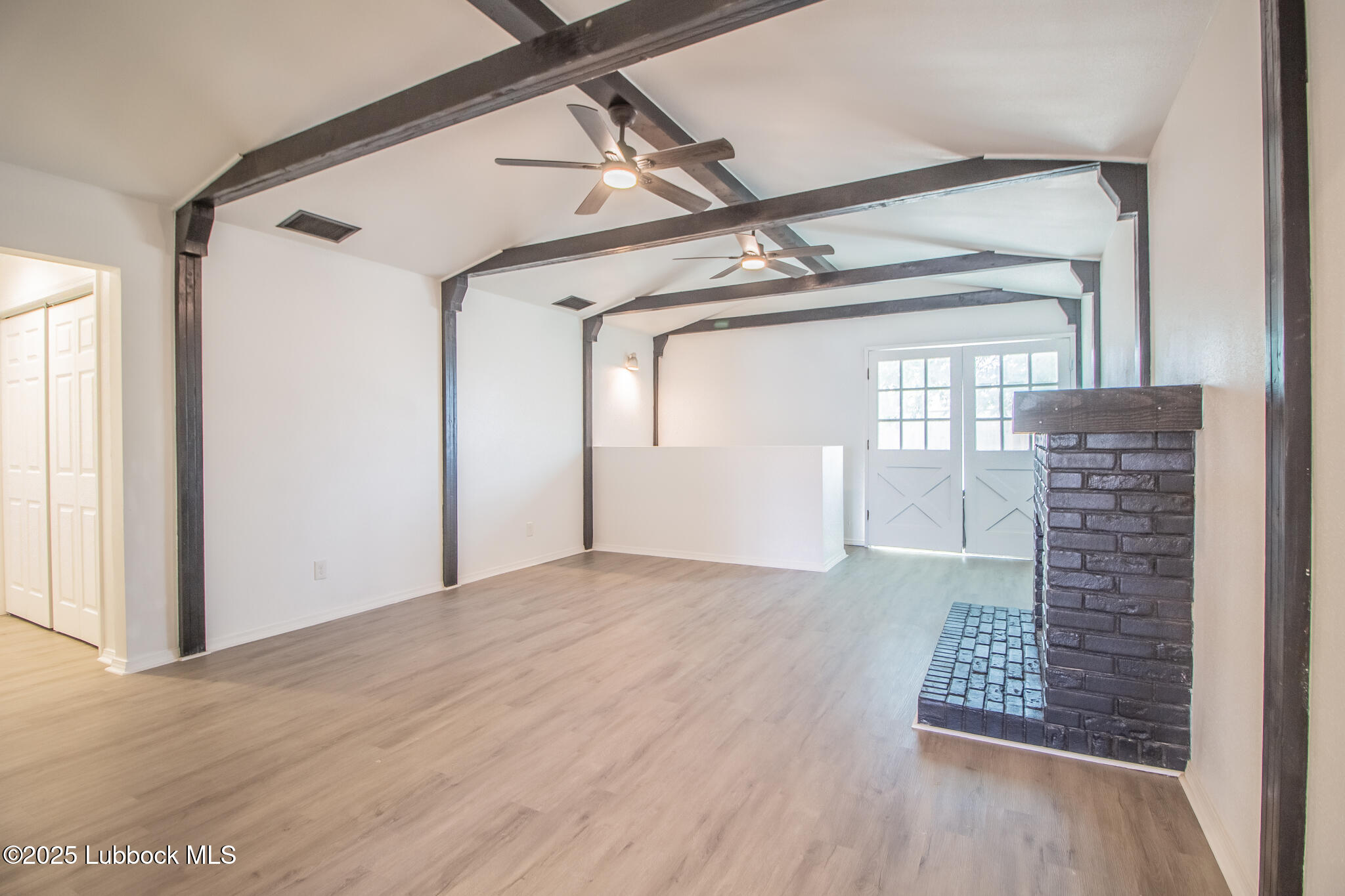 5313 39th Street Lubbock, TX 79414 - Photo 12 of 30 a view of an empty room with wooden floor and windows