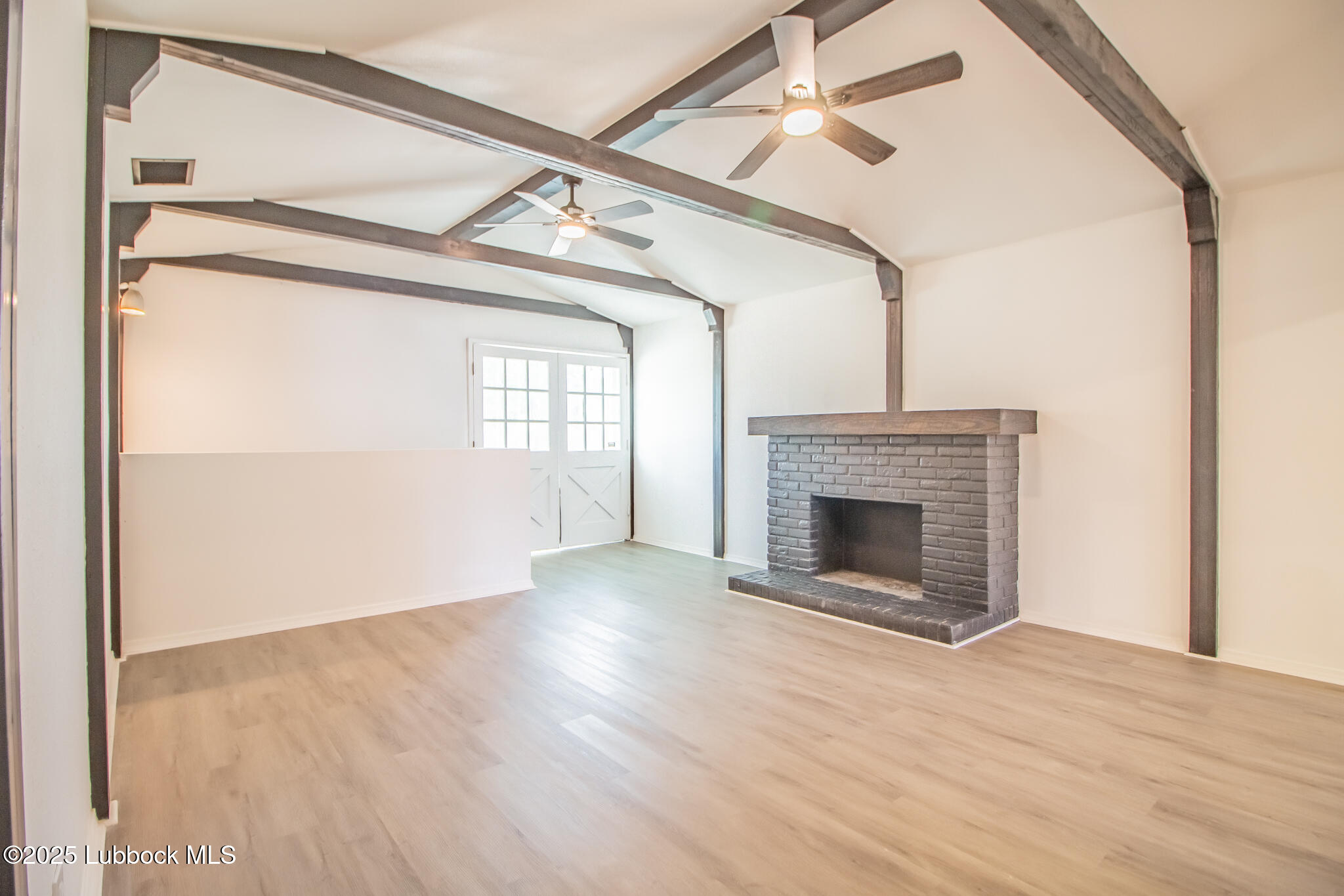 5313 39th Street Lubbock, TX 79414 - Photo 13 of 30 a view of a livingroom with a fireplace a ceiling fan and wooden floor