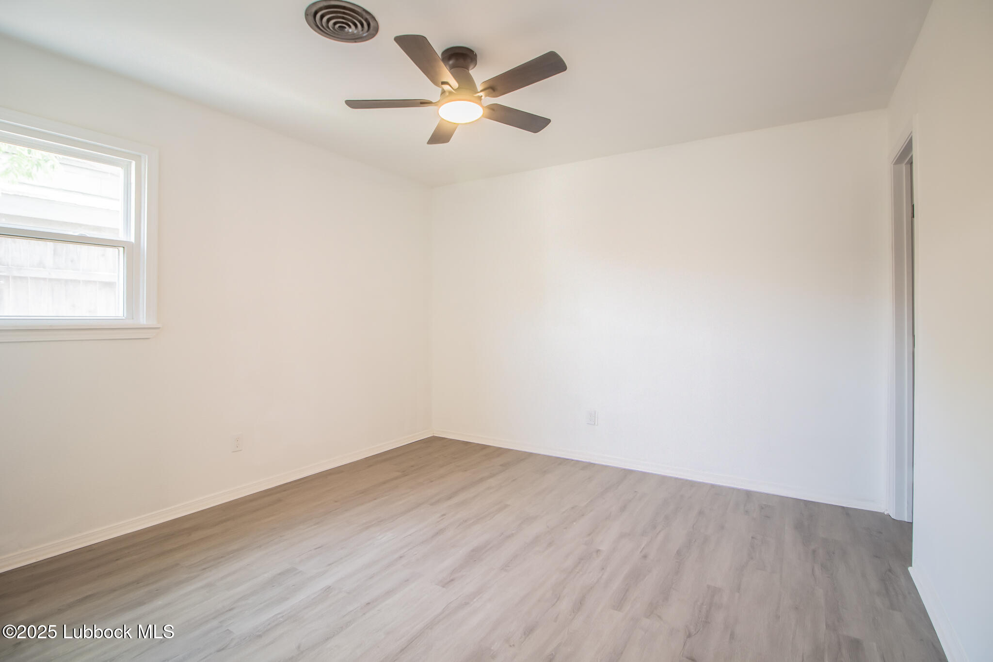 5313 39th Street Lubbock, TX 79414 - Photo 19 of 30 an empty room with wooden floor and windows