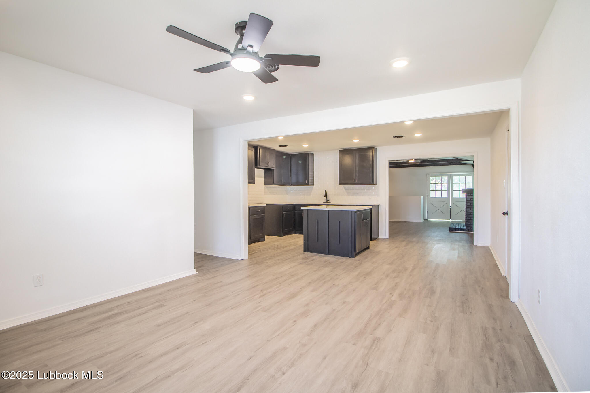 5313 39th Street Lubbock, TX 79414 - Photo 7 of 30 a view of a livingroom with a ceiling fan a kitchen and a chandelier fan