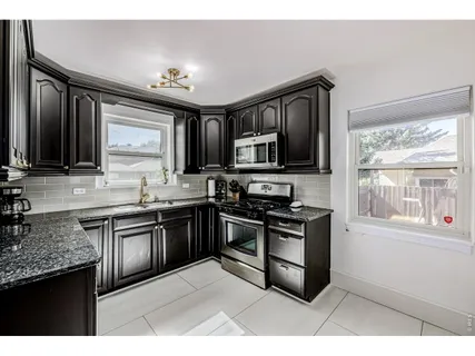 a kitchen with stainless steel appliances granite countertop a stove top oven a sink dishwasher a dining table and chairs