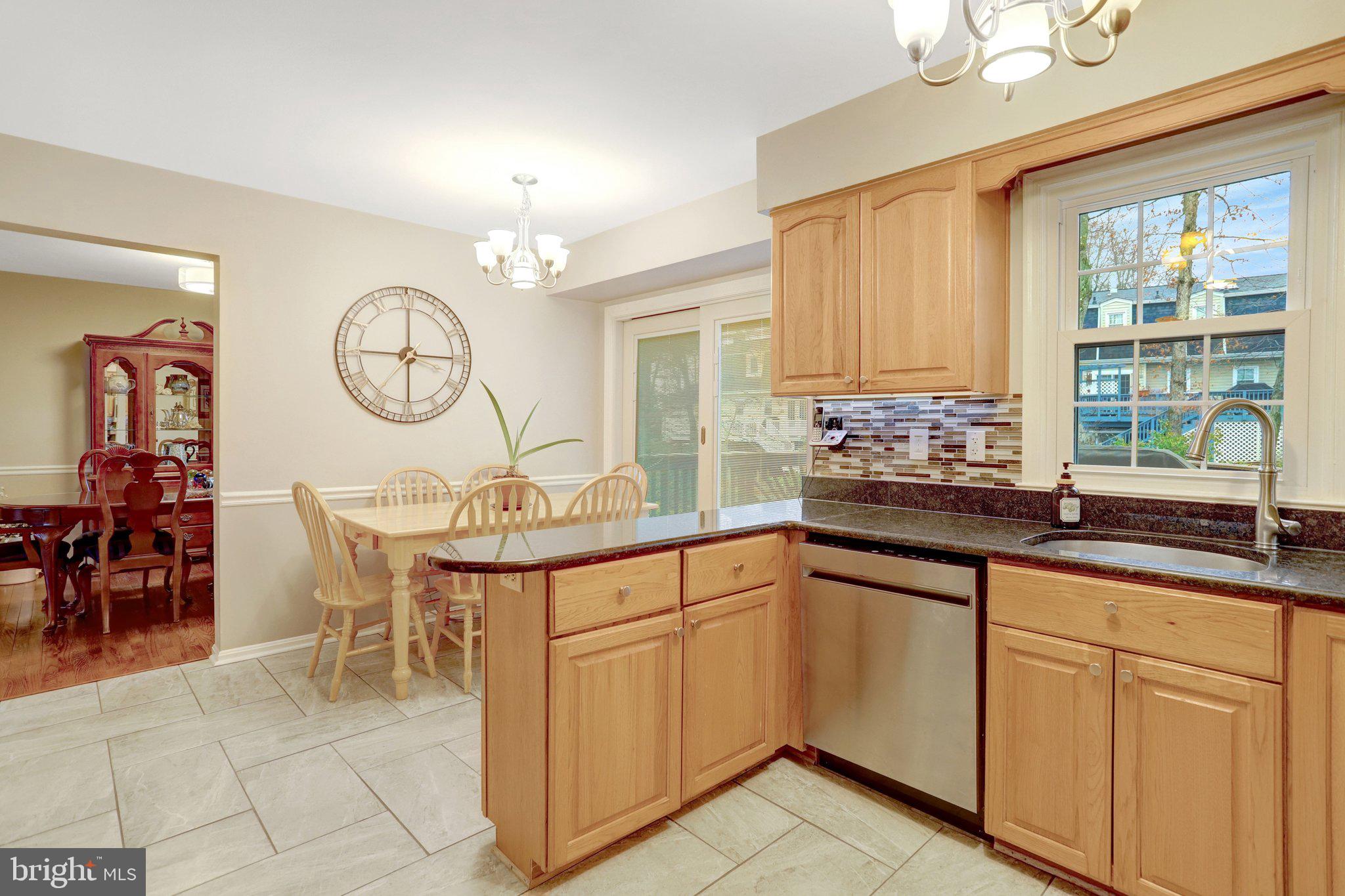 8705 Side Saddle Road Springfield, VA 22152 - Photo 18 of 73 a very nice looking open kitchen with granite countertop a sink a window and a dining table chair