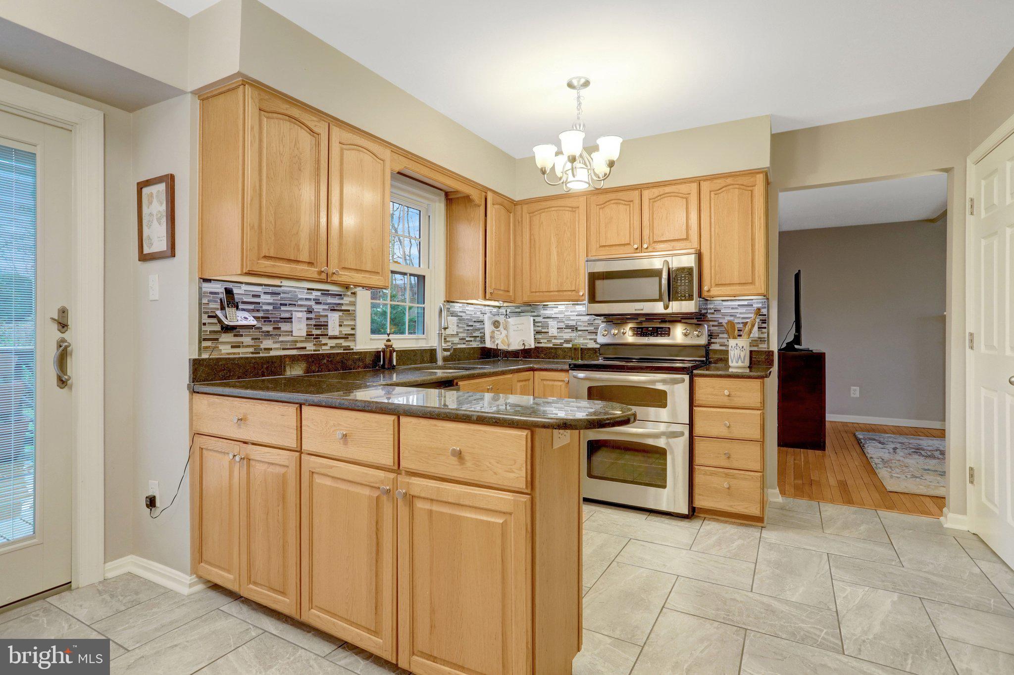 8705 Side Saddle Road Springfield, VA 22152 - Photo 20 of 73 a kitchen with stainless steel appliances granite countertop a stove and a refrigerator