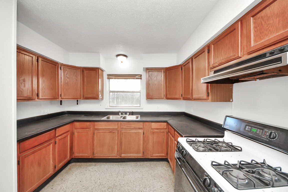 201 Delta Street Pasadena, TX 77506 - Photo 12 of 33 a kitchen with stainless steel appliances granite countertop a stove sink and cabinets