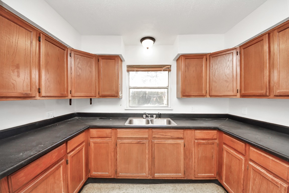 201 Delta Street Pasadena, TX 77506 - Photo 13 of 33 a kitchen with granite countertop cabinets sink and window