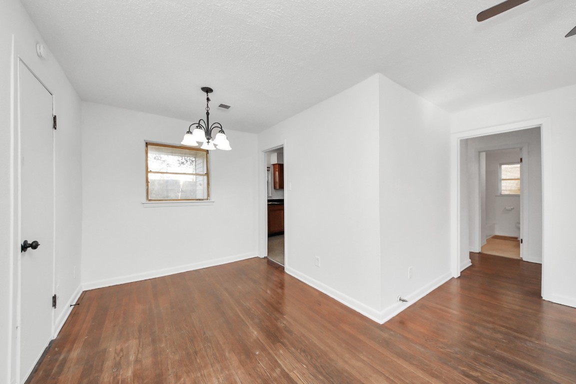201 Delta Street Pasadena, TX 77506 - Photo 10 of 33 an empty room with wooden floor chandelier and windows