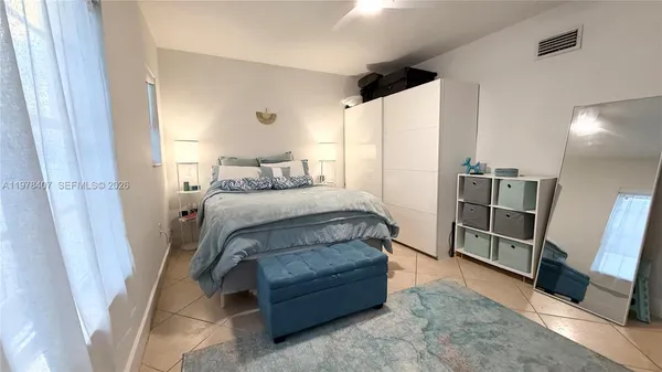 a bedroom with a bed and a mirror in it