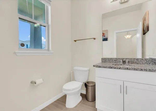 a bathroom with a granite countertop toilet and a sink
