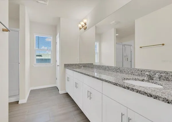 a bathroom with a granite countertop sink and a mirror