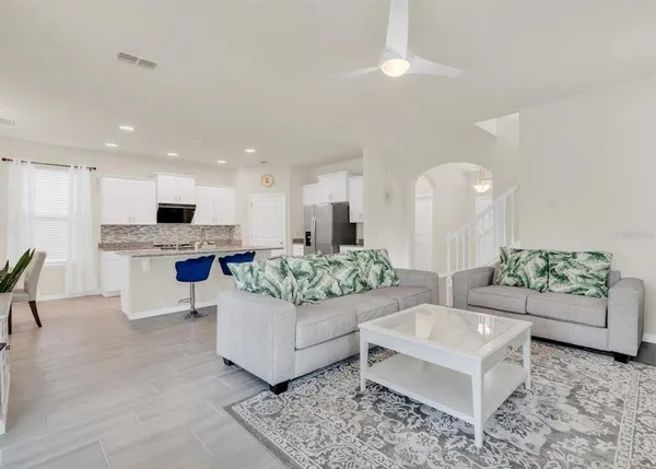 a living room with furniture and kitchen view