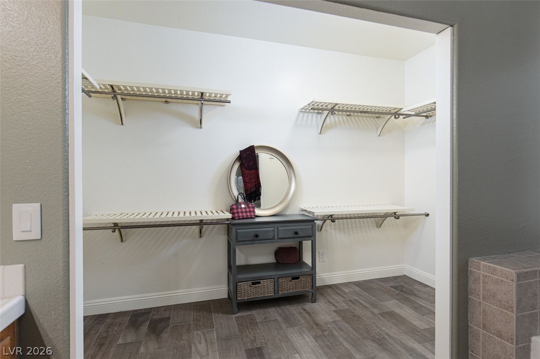 4670 Los Rancheros Avenue Las Vegas, NV 89129 - Photo 27 of 57 A spacious walk-in closet features built-in wire shelving and durable wood-look tile flooring.