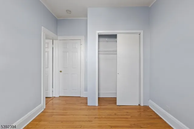 a view of an empty room with wooden floor and entryway