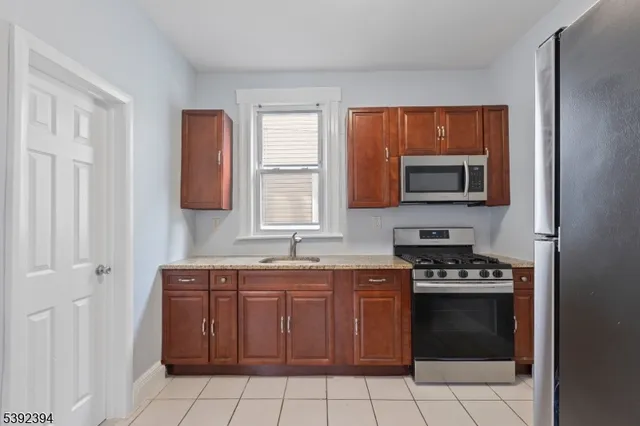 a kitchen with stainless steel appliances a stove sink and microwave